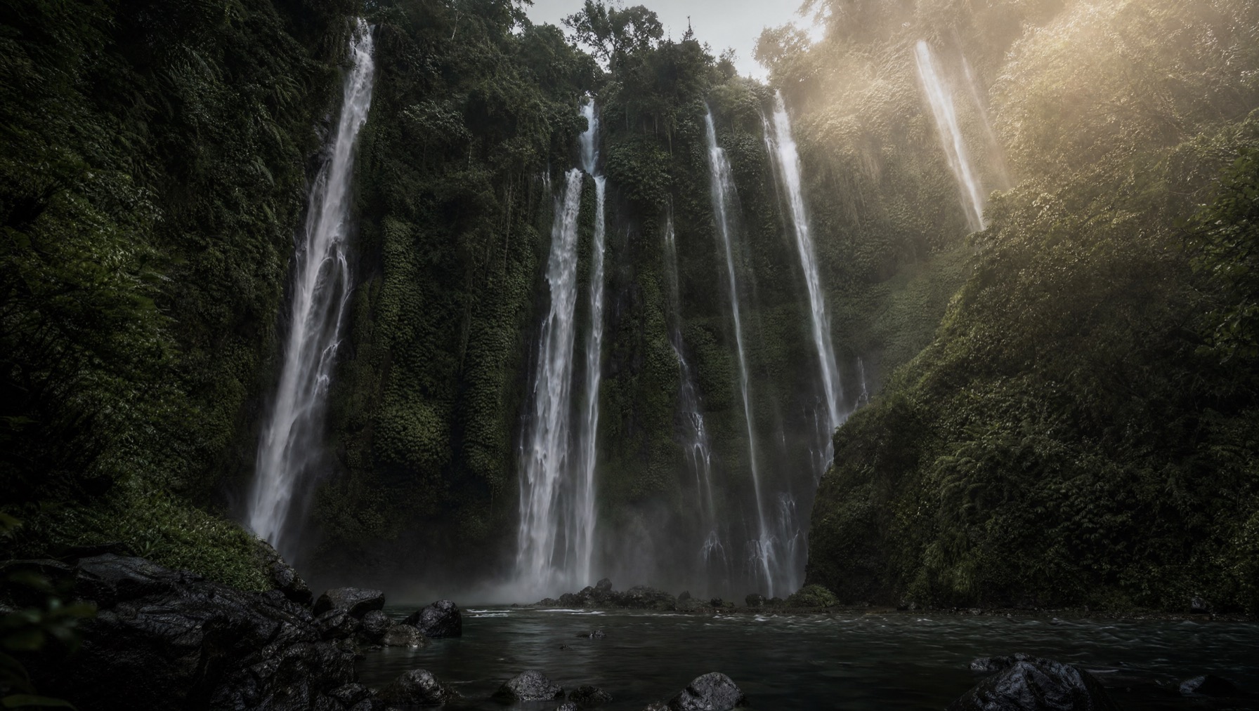 Three parallel waterfalls dropping through jungle in the Sekumpul valley, north Bali