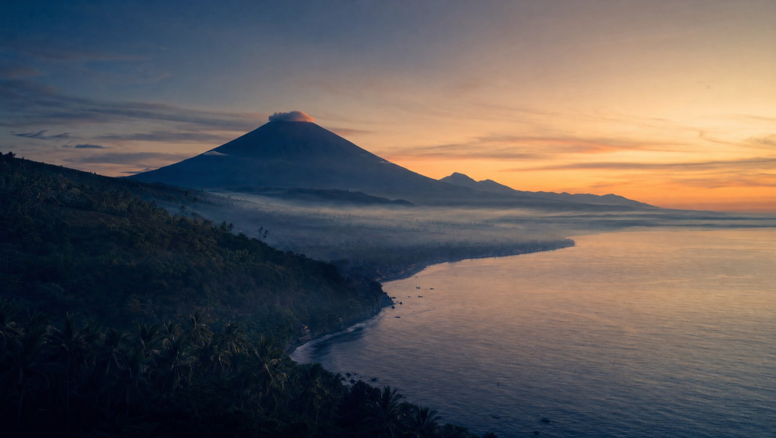 Sweeping north Bali vista at dawn with calm sea and misty hills