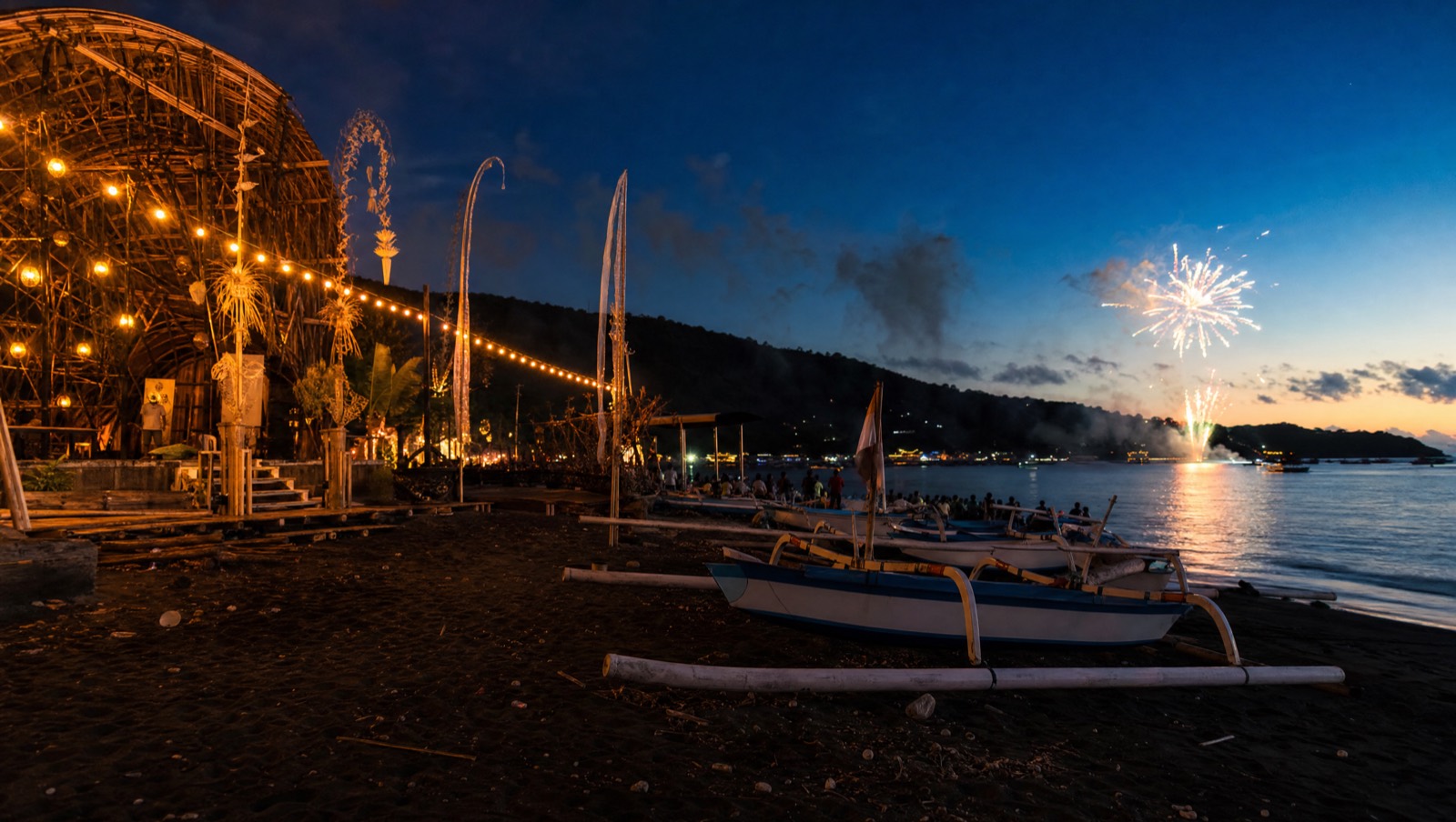 Evening crowd and traditional boats on Lovina beach during the Lovina Festival, north Bali
