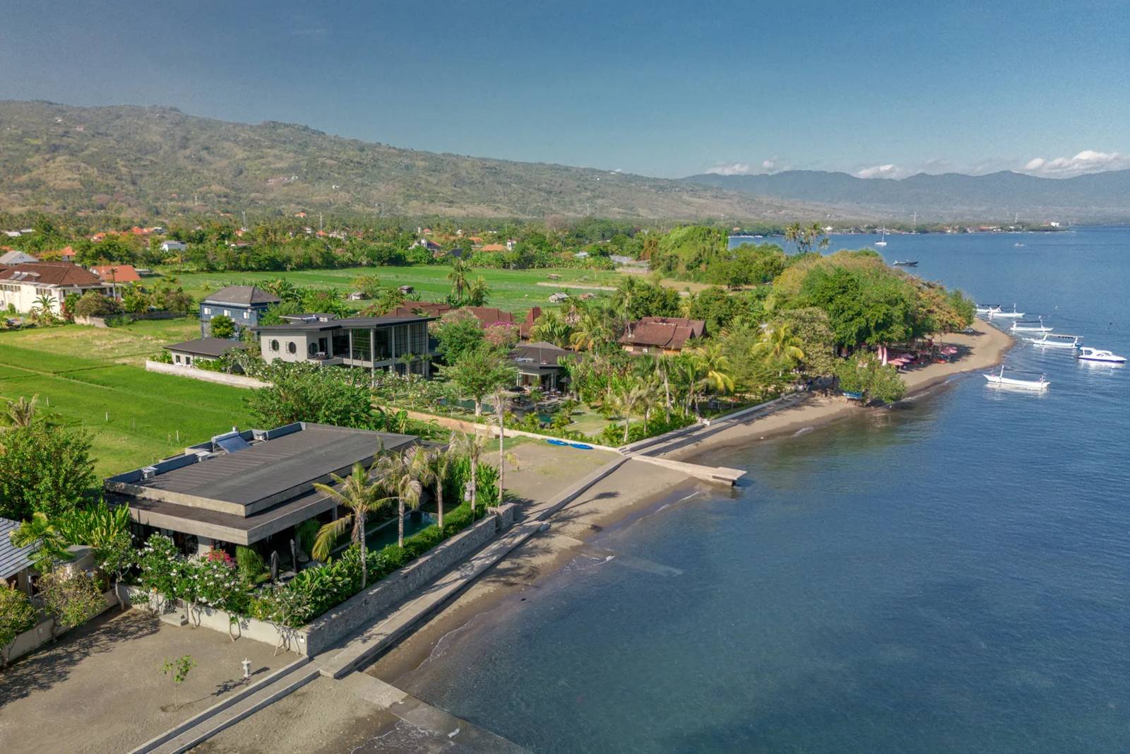 Aerial view of the Lovina shore with the two Sea View villas beside the beach, rice fields and mountains behind