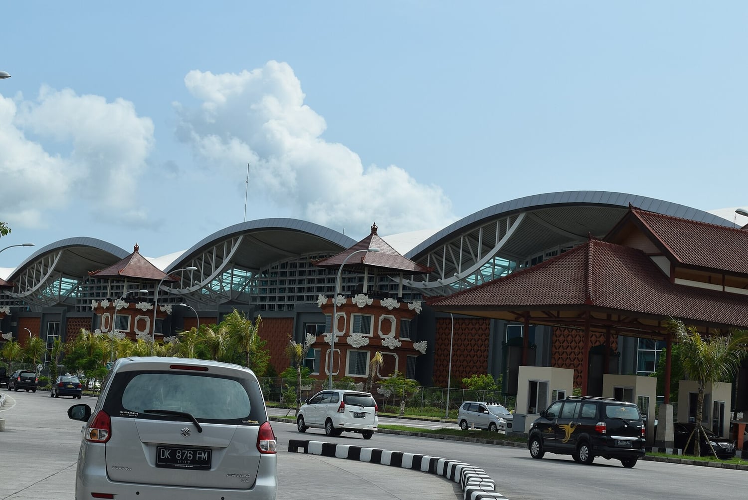 Cars outside the wave-roofed terminal at Ngurah Rai airport in Bali