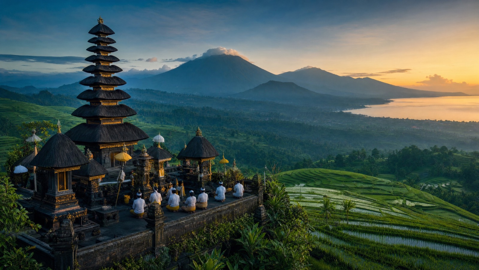 Balinese temple shrine among rice terraces with mountains and sea