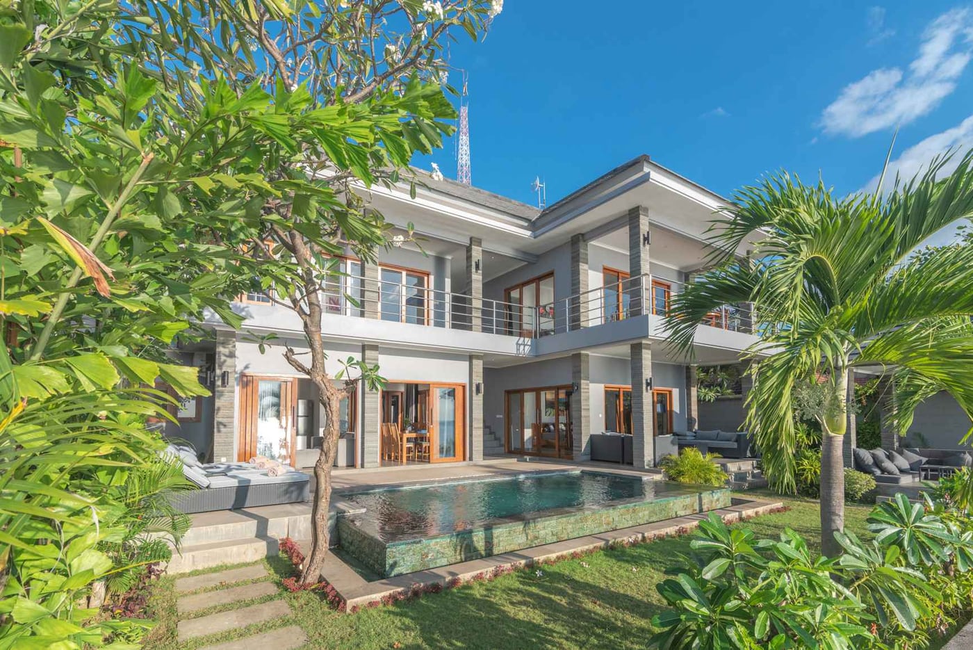 Two-storey Villa Sean with balconies and a private pool surrounded by palms, north Bali coast